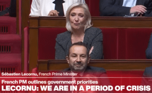 Marine Le Pen looking on with crossed arms and pursed lips. A banner below her says Lecornu: We are in a period of crisis