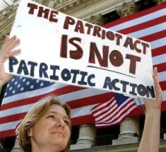 Woman holding a sign that reads "The Patriot Act is not patriotic action"